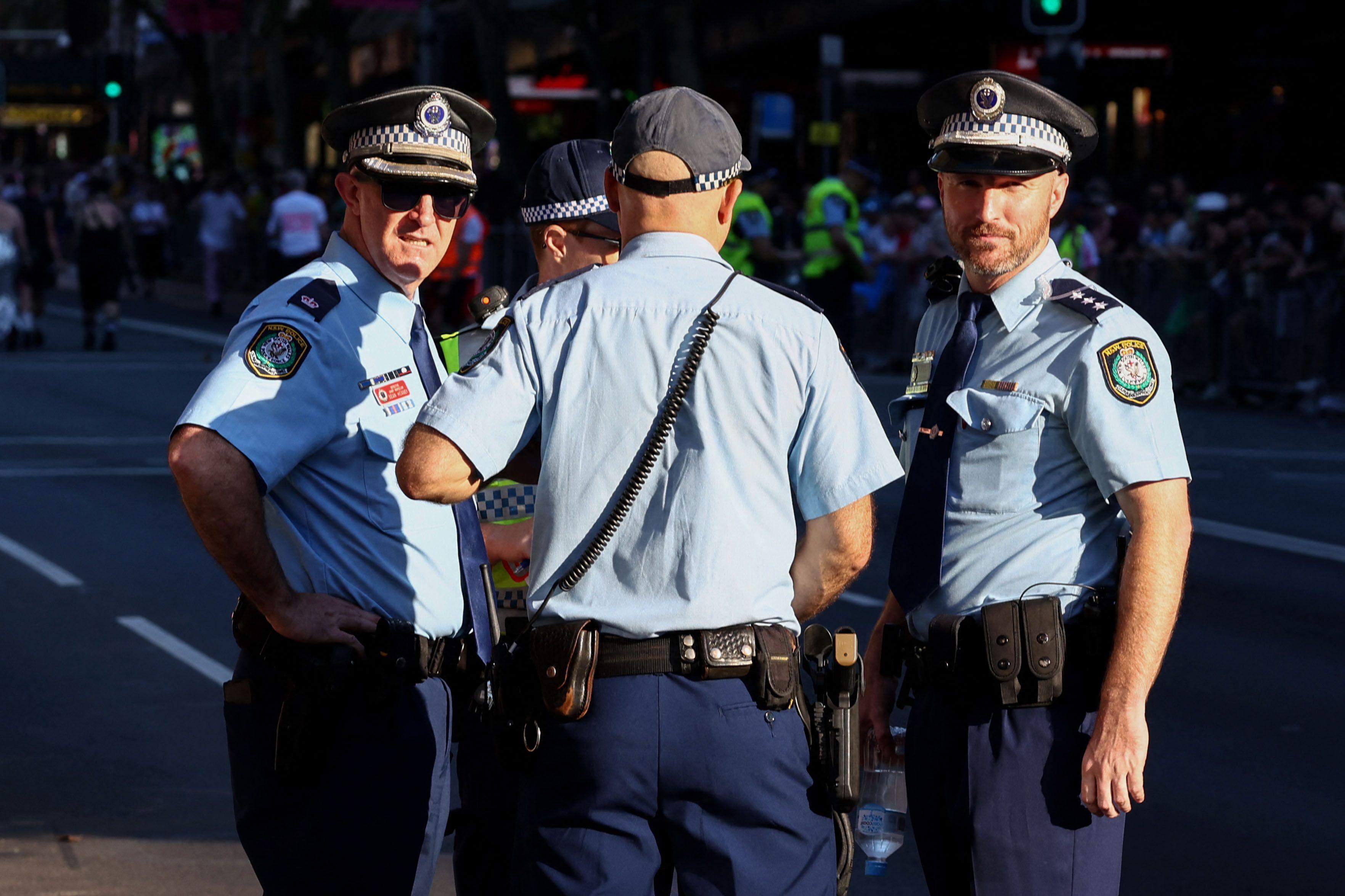 四名身穿制服的警員在街上，其中兩人望向鏡頭。