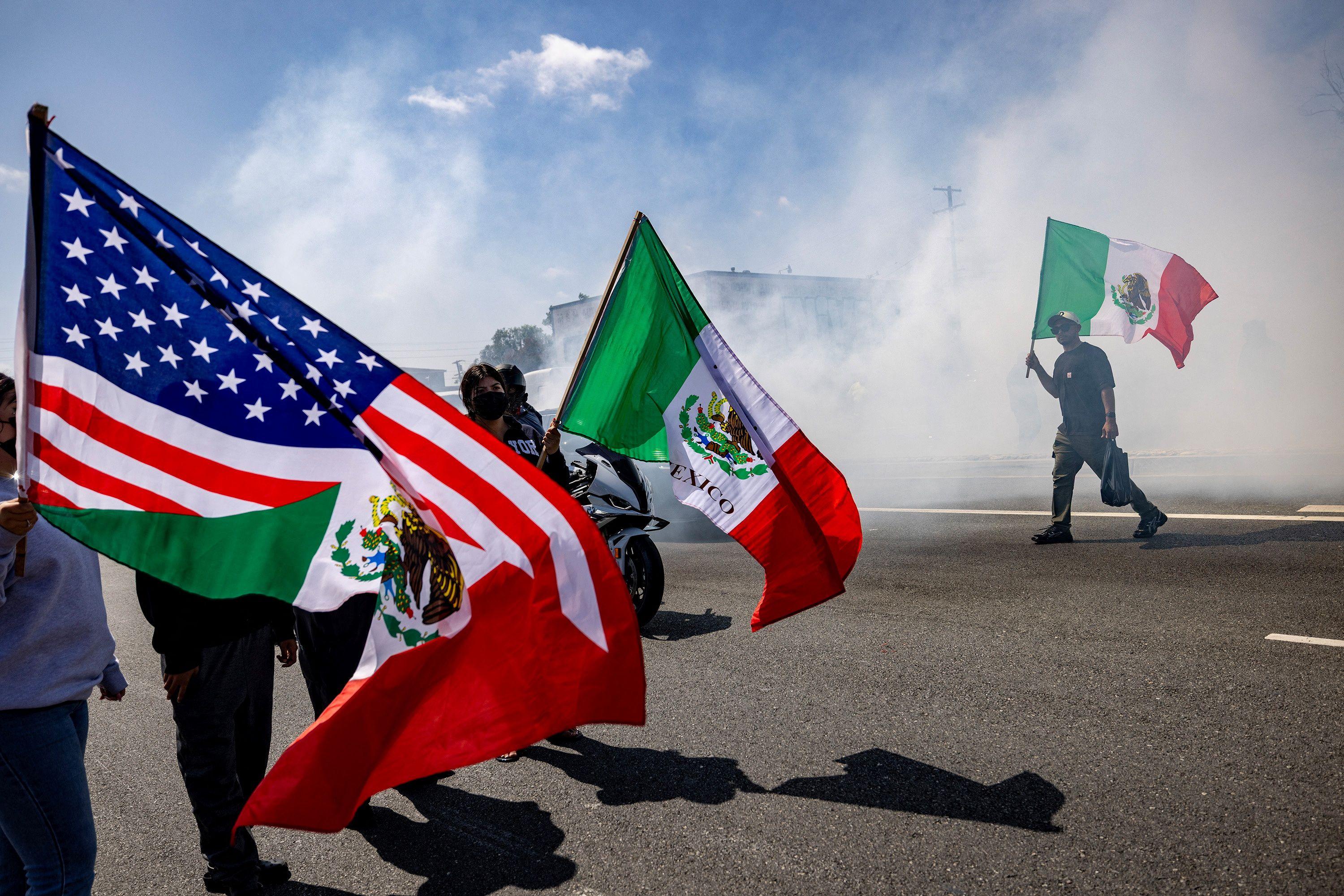 Un hombre sostiene una bandera mexicana durante un enfrentamiento entre protestantes y fuerzas del orden, tras múltiples detenciones por parte de Inmigración y Control de Aduanas (ICE), en la ciudad de Paramount, en el condado de Los Ángeles, California, EE. UU., 7 de junio de 2025. REUTERS/Barbara Davidson