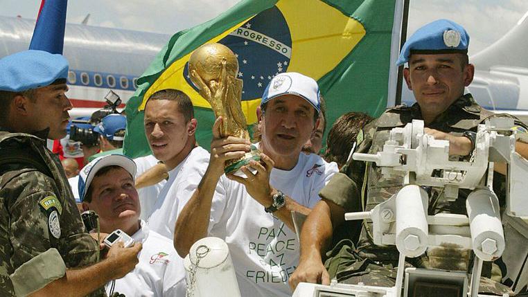 A sele&ccedil;&atilde;o brasileira exibe o trof&eacute;u da Copa do Mundo no Haiti em 2004, acompanhada por for&ccedil;as de paz da ONU