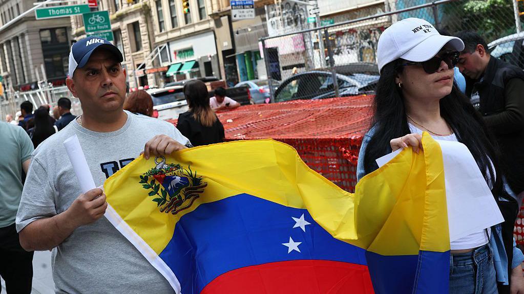 Dos personas con la bandera venezolana en Nueva York.