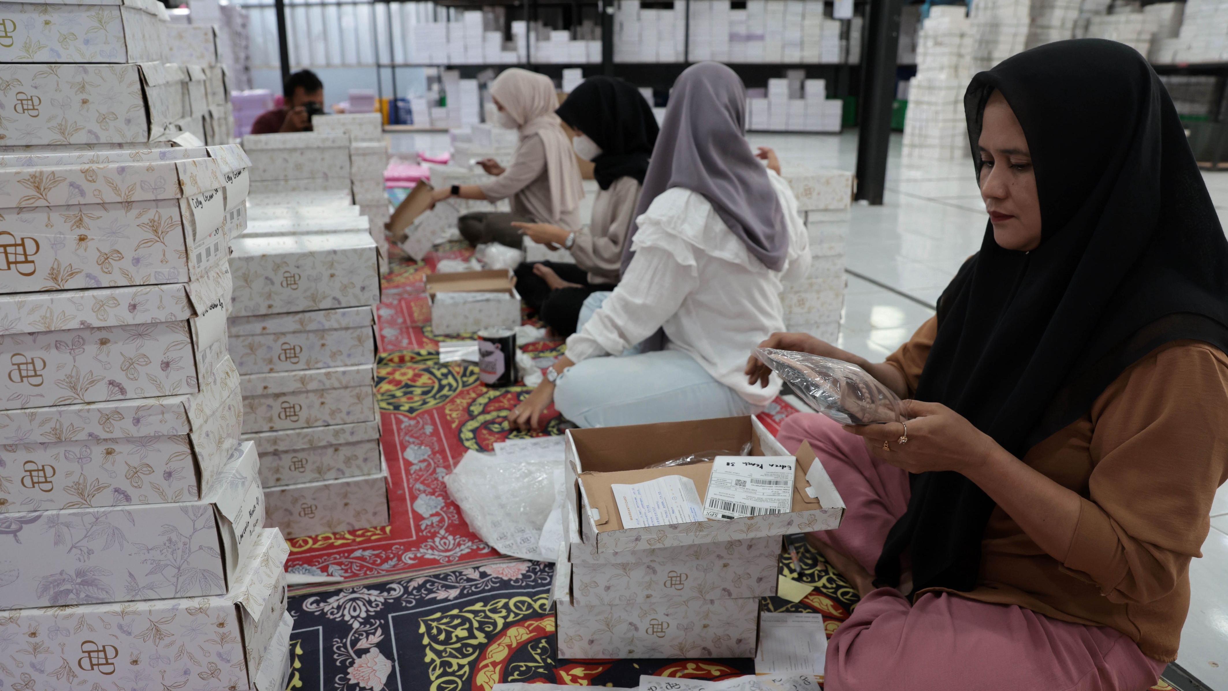 Para pekerja mengemasi sepatu dan tas di pabrik sepatu dan tas wanita Patris di Bogor, Indonesia, 14 April 2025. Pabrik sepatu Patris mengelola sekitar 10 Usaha Mikro, Kecil, dan Menengah (UMKM) dengan sekitar 300 pekerja UMKM. Pabrik ini mengandalkan platform daring untuk menjual produknya ke berbagai negara, termasuk Amerika Serikat. Alas kaki merupakan komoditas ekspor terbesar ketiga Indonesia ke Amerika Serikat.