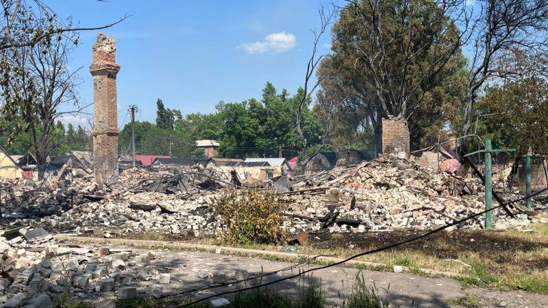 Ruínas na cidade ucraniana de Rodynske, ao lado de rua e pilar em pé
