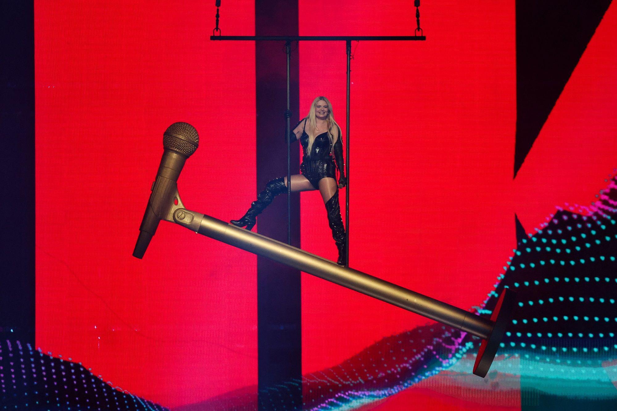 žena stoji na velikom mikrofonu na sceni