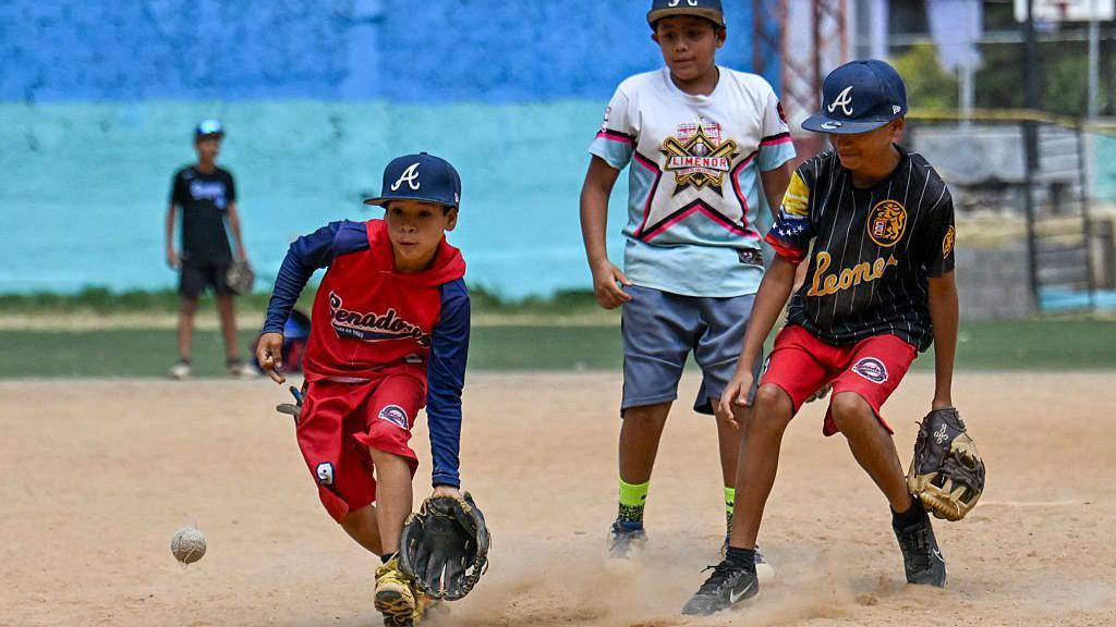Niños jugando béisbol en un campo de la urbanización 23 de enero de Caracas.