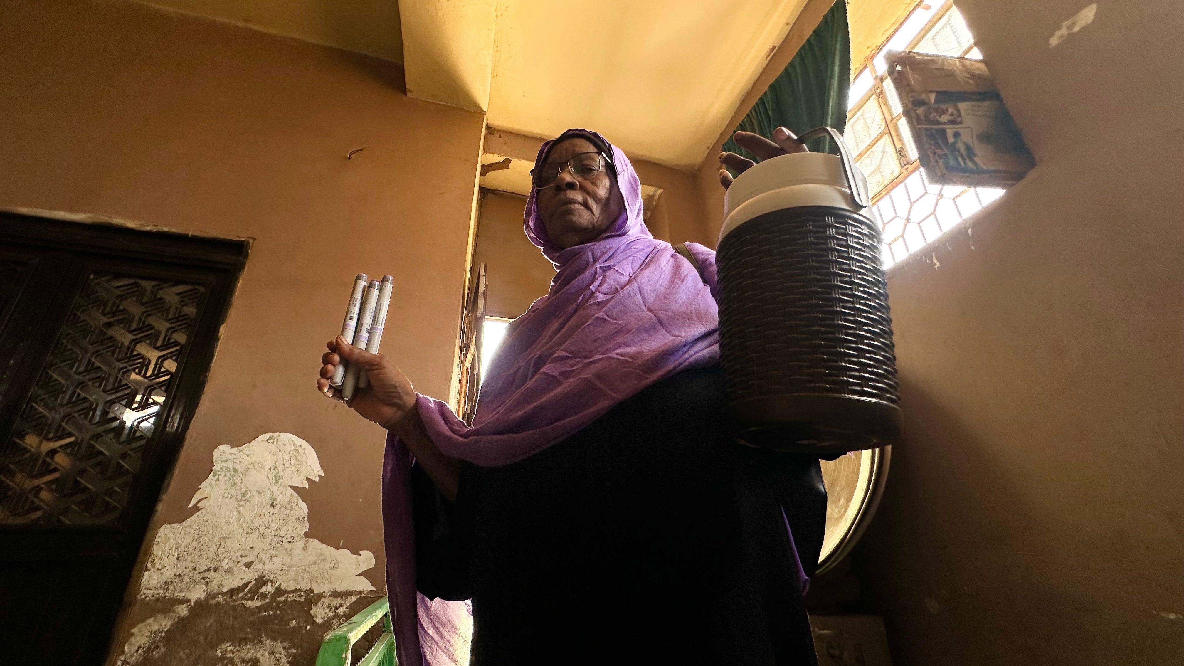 امرأة من السودان تحمل حافظة الصلح بيدها اليسرى.