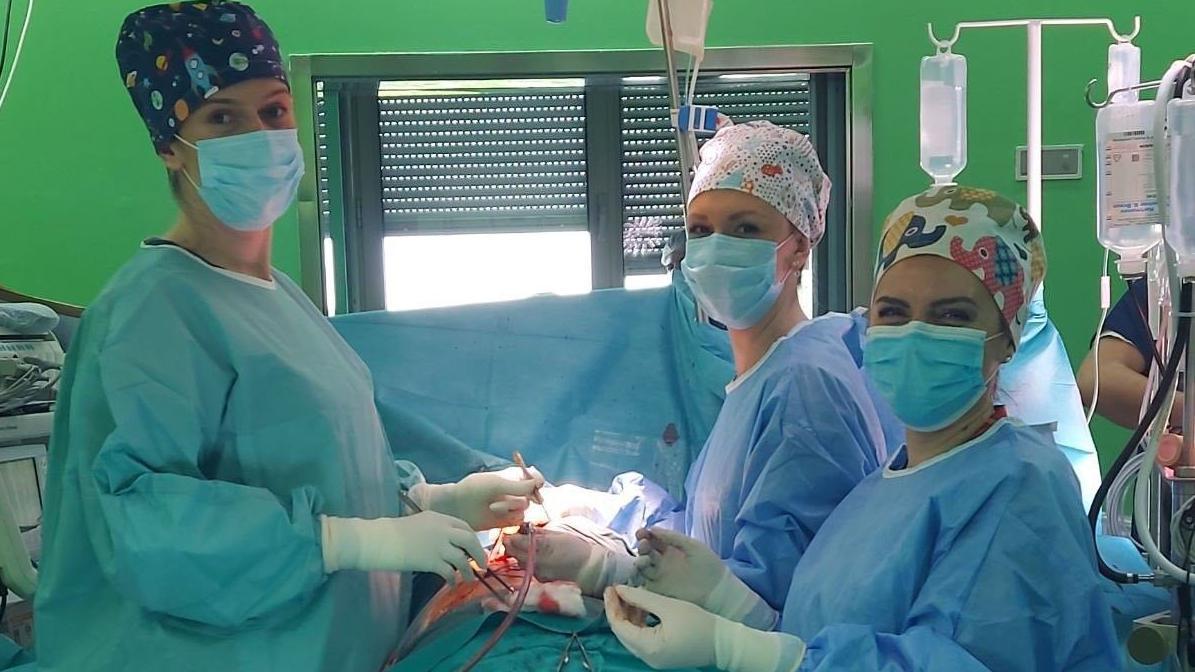 Tri žene u operacionoj sali obučene u hirurške uniforme