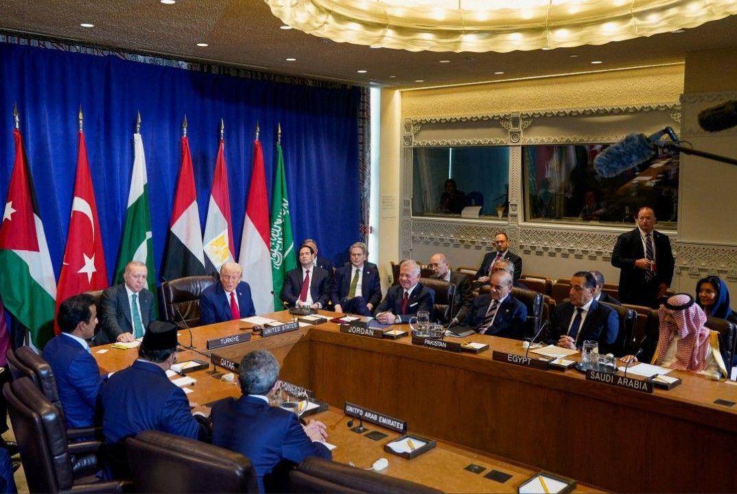 الرئيس الأمريكي دونالد ترامب يتحدث بجوار وزير الخارجية الأمريكي ماركو روبيو ووزير الخزانة الأمريكي سكوت بيسنت خلال اجتماع متعدد الأطراف مع الرئيس التركي رجب طيب أردوغان والعاهل الأردني الملك عبد الله الثاني ورئيس الوزراء الباكستاني شهباز شريف ورئيس الوزراء المصري مصطفى مدبولي ووزير الخارجية السعودي فيصل بن فرحان آل سعود وأمير قطر الشيخ تميم بن حمد آل ثاني والرئيس الإندونيسي برابو سوبيانتو ونائب رئيس الوزراء ووزير الخارجية الإماراتي عبد الله بن زايد آل نهيان. يجلسون جميعاً على طاولة اجتماعات شكلها تقريباً بيضاوي وفارغة من المنتصف، لونها بني. على رأس الطاولة يجلس ترامب وبجانبه تماماً أردوغان. وخلفهم أعلام الدول المجتمعة.