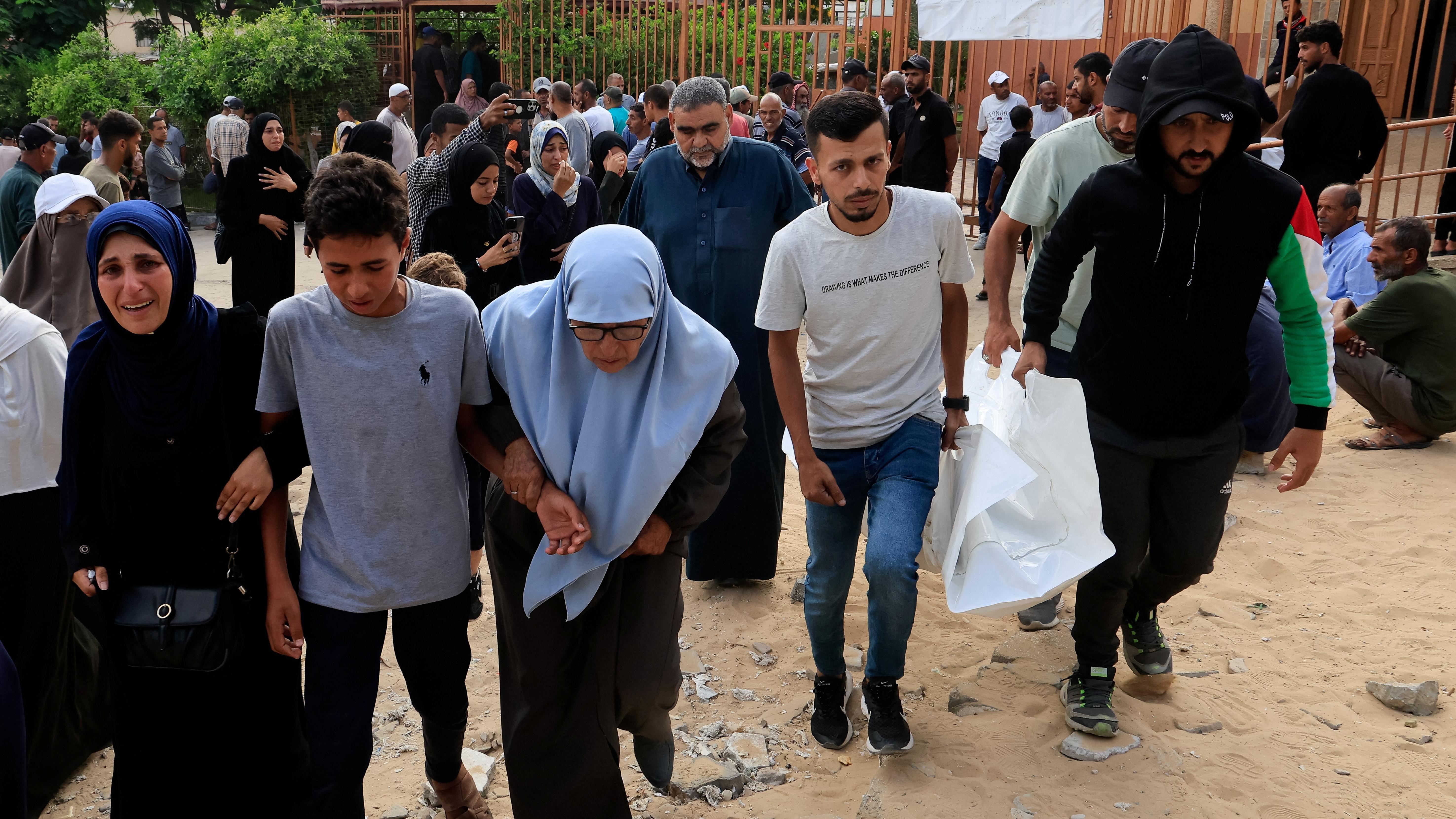 يتفاعل المشيعون خلال جنازة الفلسطينيين الذين قتلوا في الغارات الإسرائيلية الصباحية على الخيام التي تؤوي النازحين، وفقًا للمسعفين، في مستشفى ناصر في خان يونس، جنوب قطاع غزة. 