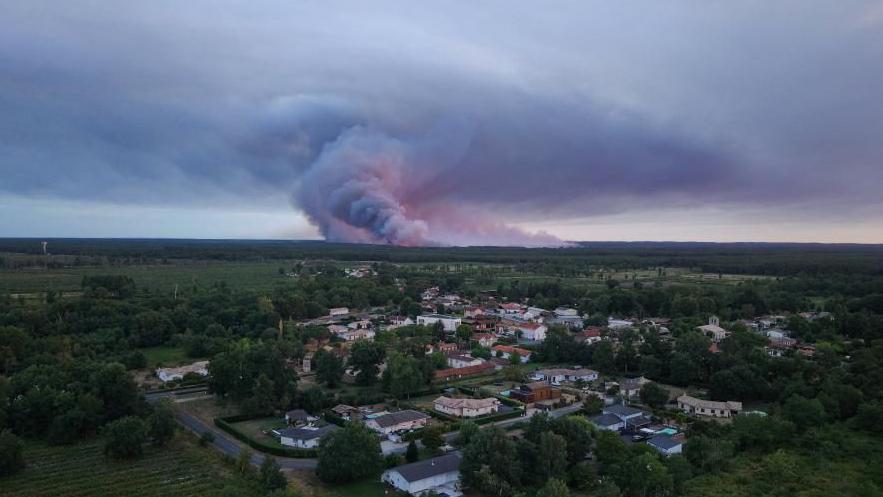 Fotografija prikazuje opštinu Sent-Elen u Francuskoj gde se vidi dim koji se diže u pozadini tokom šumskog požara u šumskom području u Saumosu
