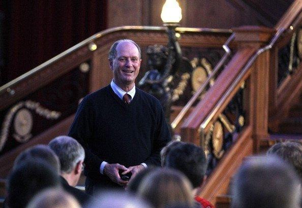 Robert Ballard, un hombre de mediana edad con calvicie prematura, se dirige a un grupo de personas frente a una exposición del Titanic