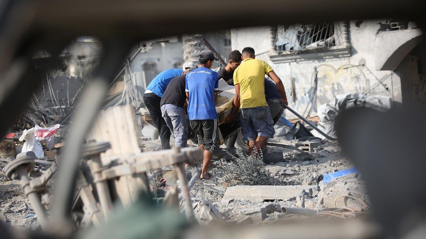 فلسطينيون يبحثون بين أنقاض منازلهم المدمرة عن أي ممتلكات يمكن استخدامها بعد غارة جوية إسرائيلية استهدفت عدة منازل في مخيم جديد شمال غرب النصيرات بقطاع غزة في 29 يوليو/تموز 2025. دُمرت عدة منازل بالكامل في الهجوم، الذي أسفر عن مقتل العديد من الفلسطينيين