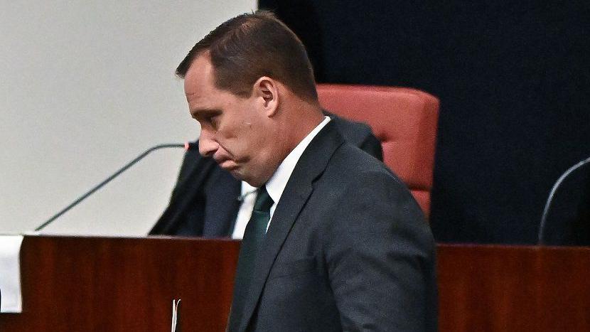 Cid caminhando em sala de audiência, olhando para baixo