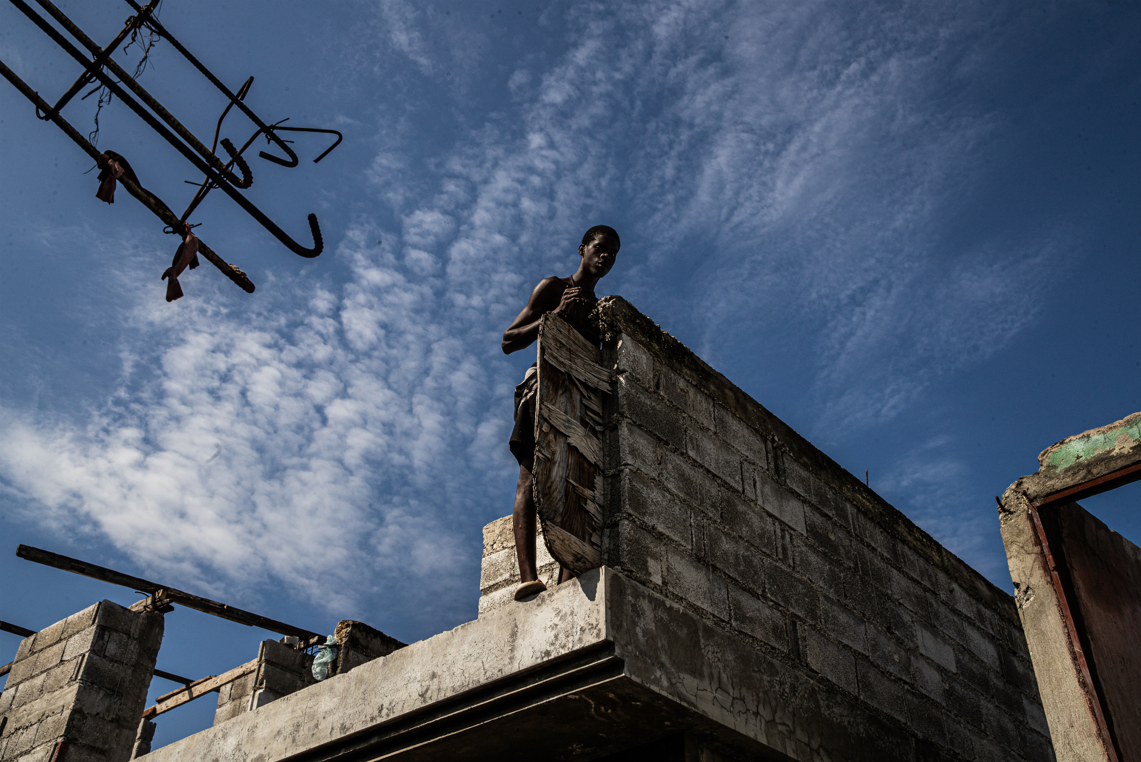 Hombre observa de pie desde el tejado de una casa destruida en el barrio de Solino en Puerto Príncipe, Haití, el 17 de febrero de 2026.
