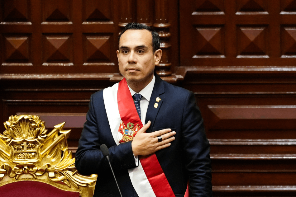 José Jerí con la banda presidencial y rostro serio se lleva la mano al pecho durante el juramento del nuevo cargo.