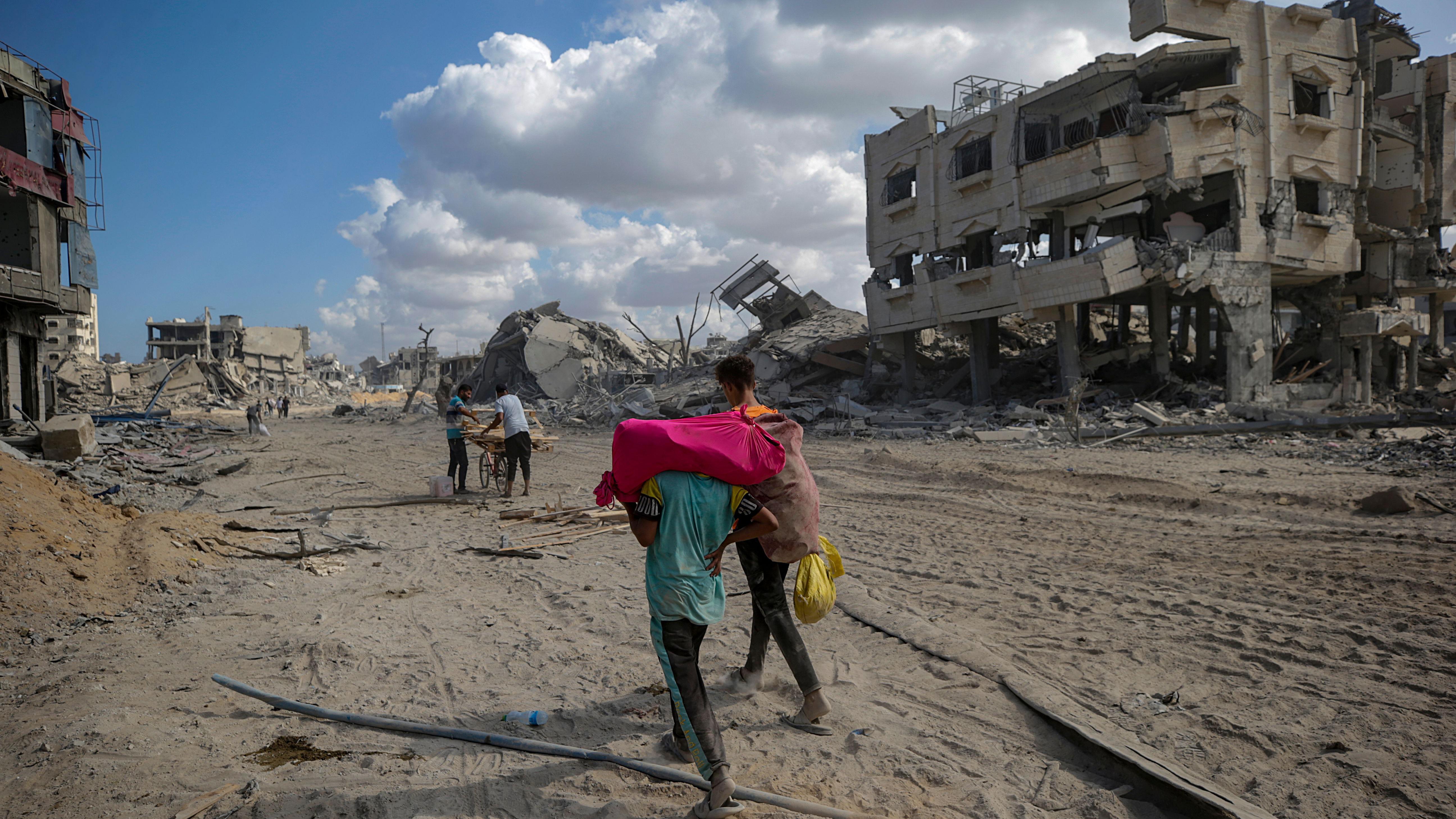 Palestinians, who were displaced to the southern part of Gaza at Israel's order during the war, make their way following their arrival in Gaza City