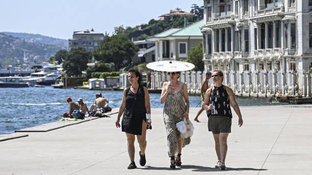 امرأة تحمل مظلة للاتقاء من حرارة الشمس اللاهبة في مدينة اسطنبول التركية التي تضربها موجة حر