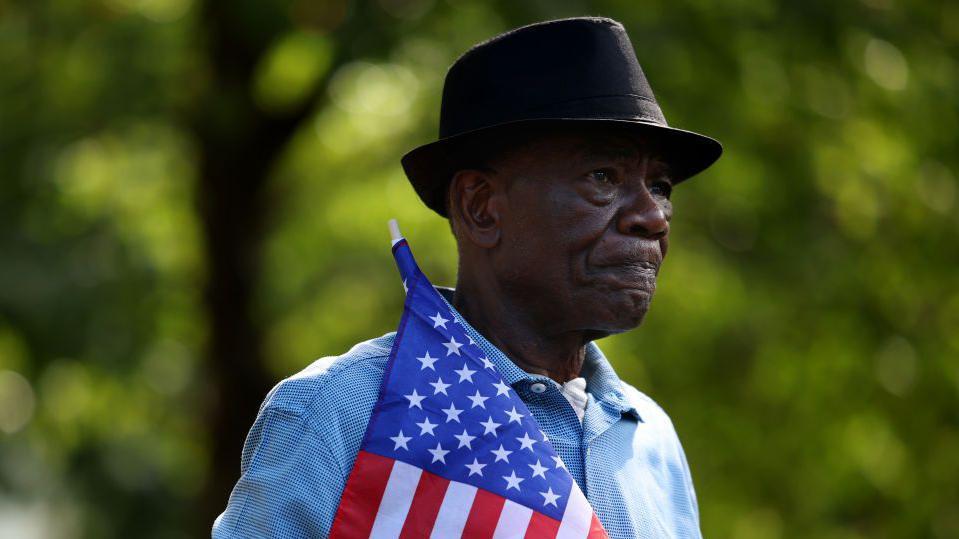  Un hombre haitiano sostiene una bandera estadounidense en Ohio, Estados Unidos. 