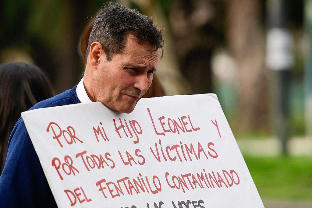 Pai de família mostra um cartaz falando sobre as vítimas do fentanil infectado