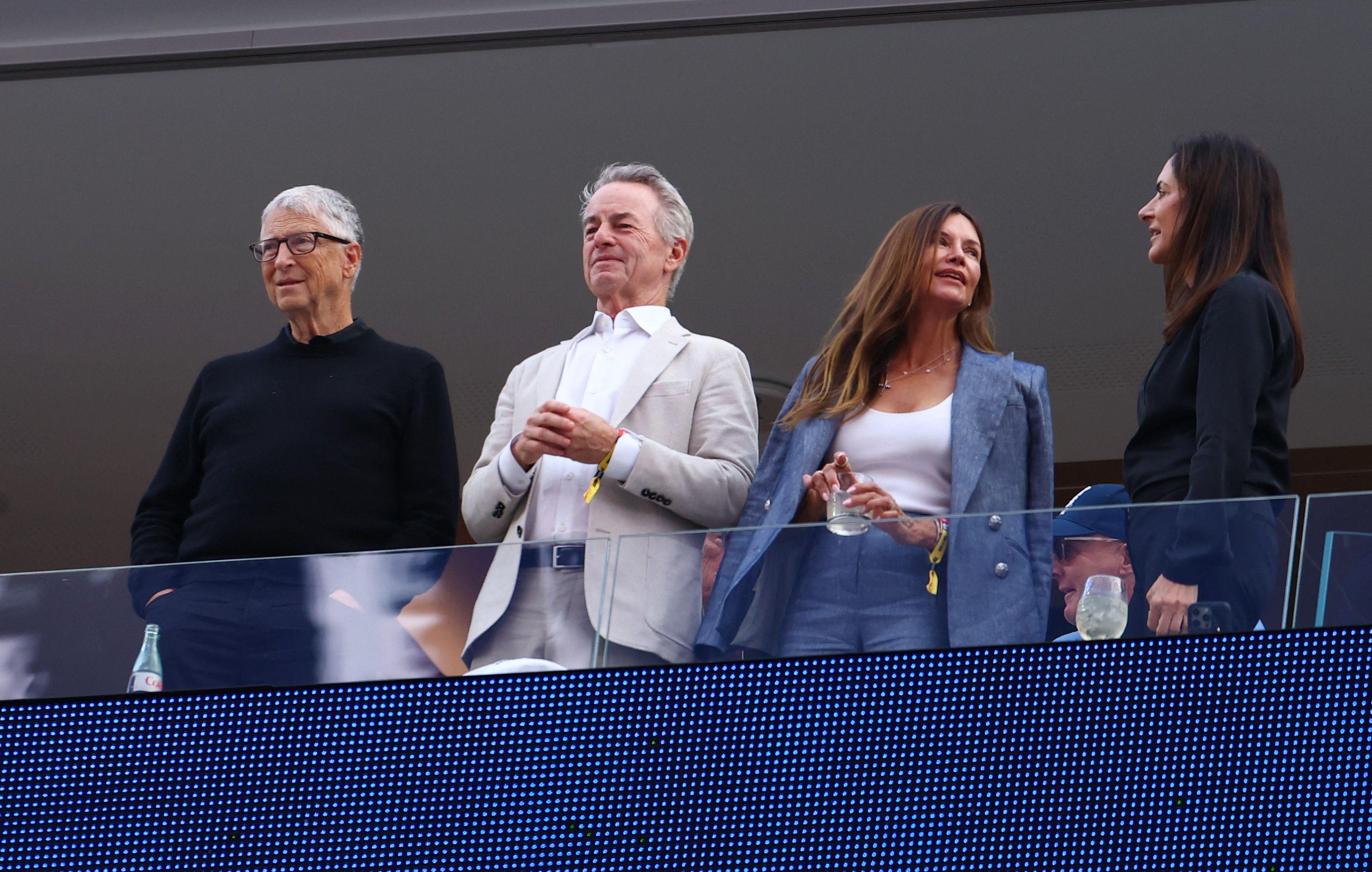 Bill Gates e outras tr&ecirc;s pessoas do alto de um camarote vendo o jogo no est&aacute;dio