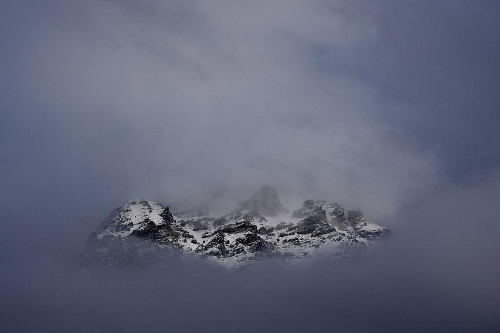 La cresta nevada de las montañas en el paso de Stelvio, entre nubes