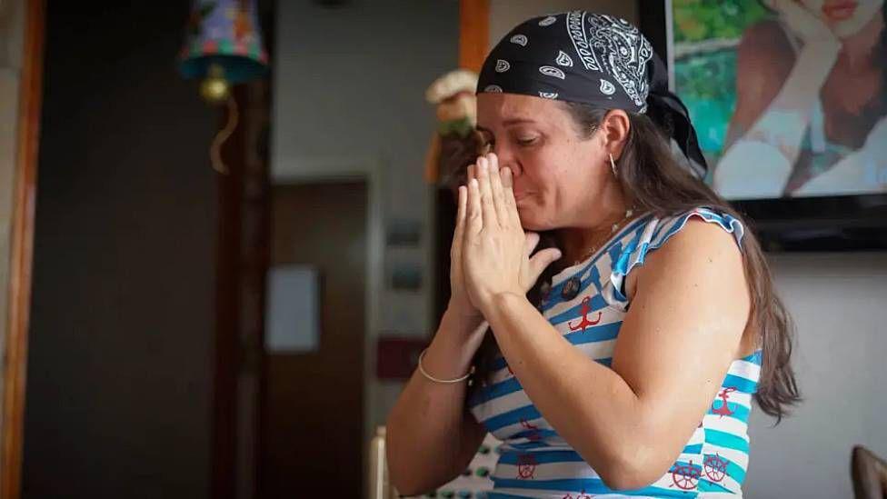 Adriana Briceño se emociona durante su conversación con la BBC al recordar las dificultades que enfrentó para saber dónde se encontraba su esposo. Es una mujer joven, tiene el pelo largo de color castaño, un pañuelo en la cabeza y una camiseta a rayas celestes y blancas