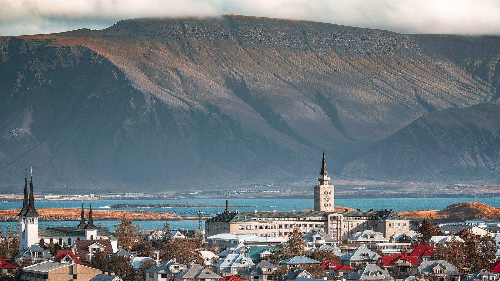 Panorámica de Reikiavik con la bahía y la cordillera volcánica Esja en el fondo y un cielo nublado