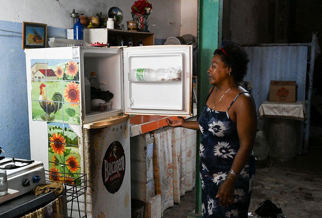 Une mujer mira dentro de su refrigerador