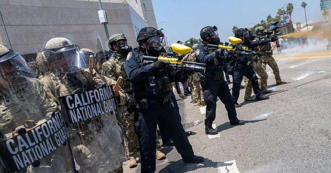 مجموعة من الحرس الوطني وقوات الأمن يحملون أسلحة ويحتمون بدروع شفافة بعضهم يرتدي لباساً أسود وآخرون يرتدون زياً عسكرياً زيتي اللون.