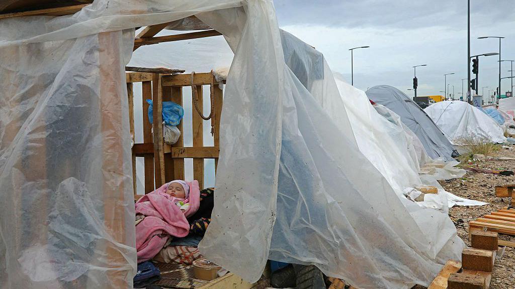 Beb&ecirc; deslocado dorme dentro de uma tenda em um estacionamento junto ao mar em Beirute, no L&iacute;bano, no dia 22 de mar&ccedil;o de 2026
