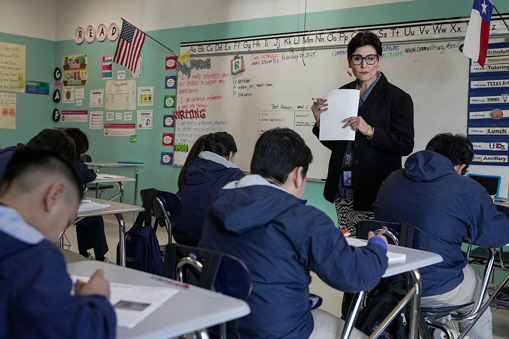 Una maestra y sus alumnos en un salón de clase.