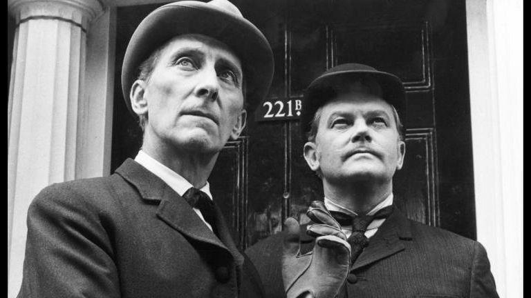 Crno-bela fotografija glumaca sa šeširima koji tumače Artura Konana Dojla i Doktora Votsona