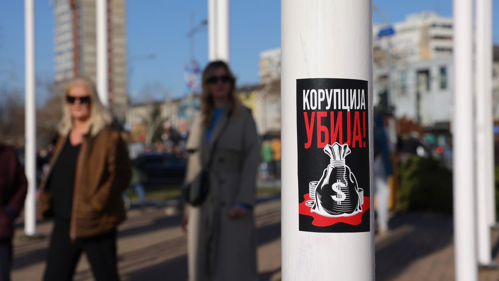 Korupcija u Beogradu: 'Kancer društva u metastazi' 1 Na banderi je poster na kojem piše - korupcija ubija a ispod je nacrtan džak sa simbolom američkog dolara