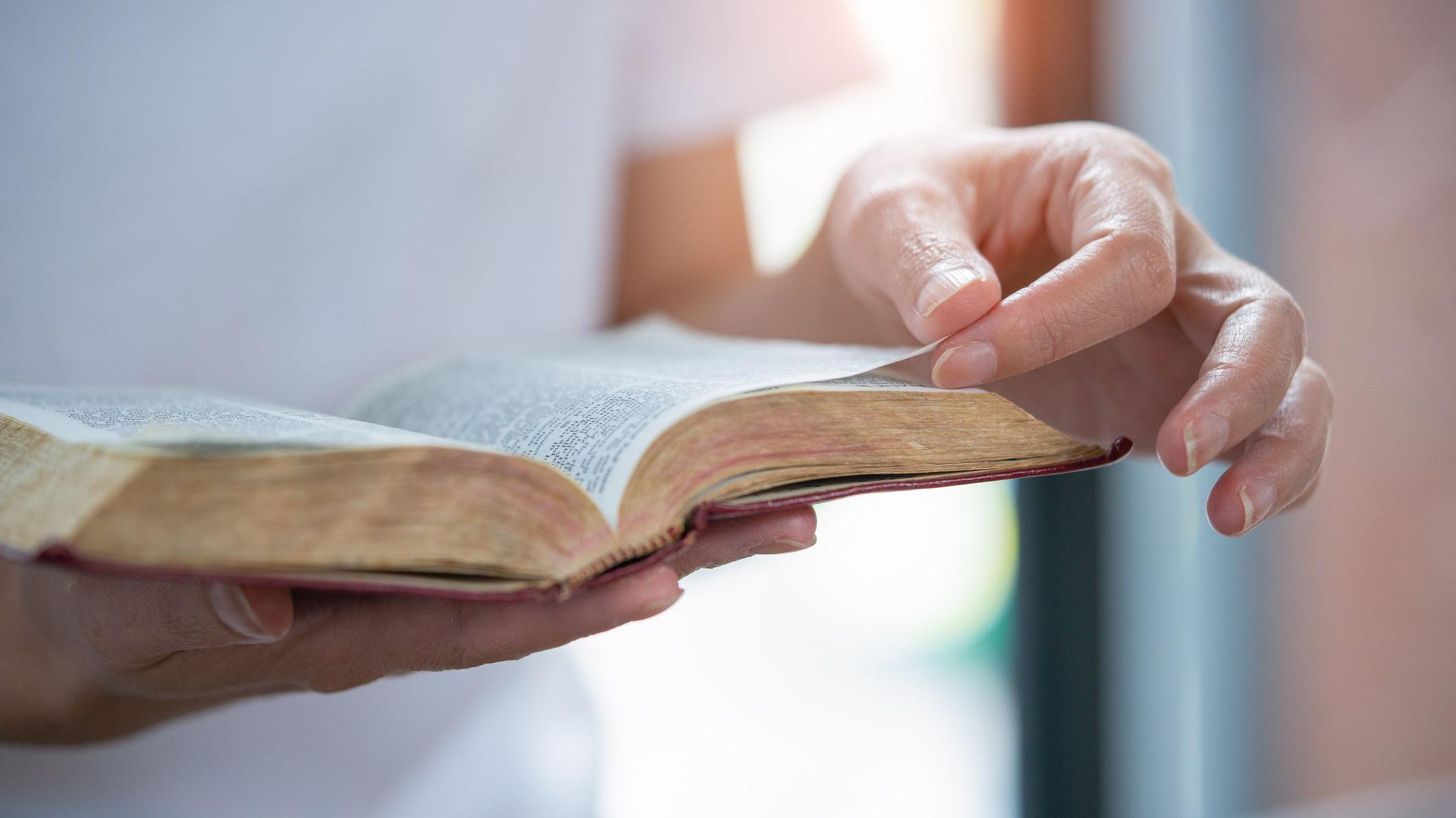 Foto de uma pessoa lendo a Bíblia.