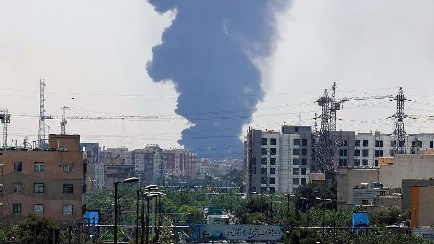Asap membumbung setelah Israel melancarkan serangan di bab selatan Teheran, pada Minggu (15/06).