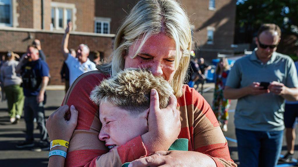 Una madre abraza a su hijo tras un tiroteo en la Iglesia de la escuela católica Annunciation, en Minneapolis, Minnesota, el miércoles 27 de agosto de 2025.