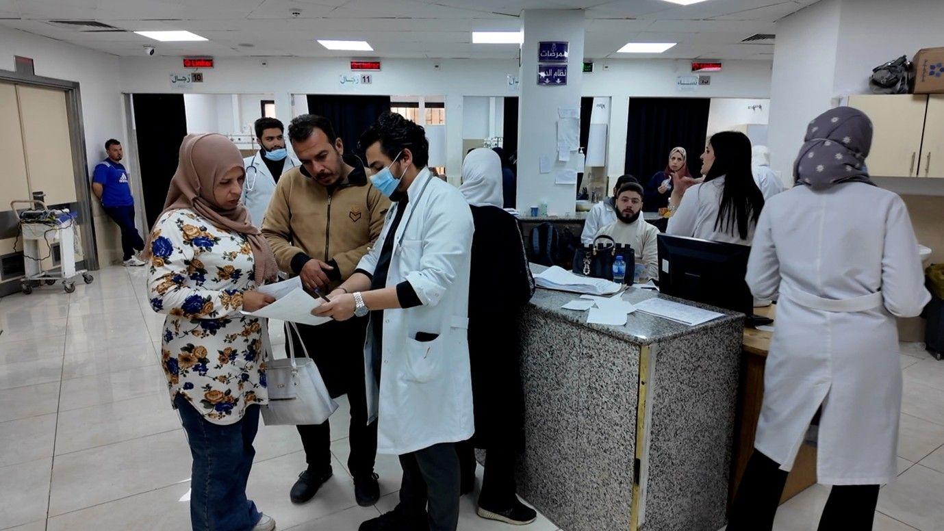 صورة داخل مستشفى حكومي يجمع عددا من الموظفين والأطباء وشخصين يستفسران عن أمر ما من الطبيب.