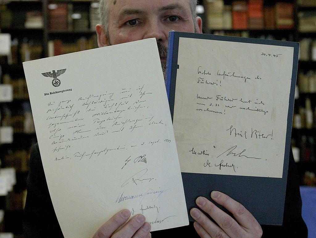 Um funcionário da casa de leilões berlinense 'Jeschke, Greve and Hauff' exibe uma cópia da última cópia em circulação dos falsos diários de Hitler, do falecido falsificador Konrad Kujau, em Berlim, em 23 de abril de 2004. Um participante anônimo do leilão adquiriu o diário por 6.500 euros