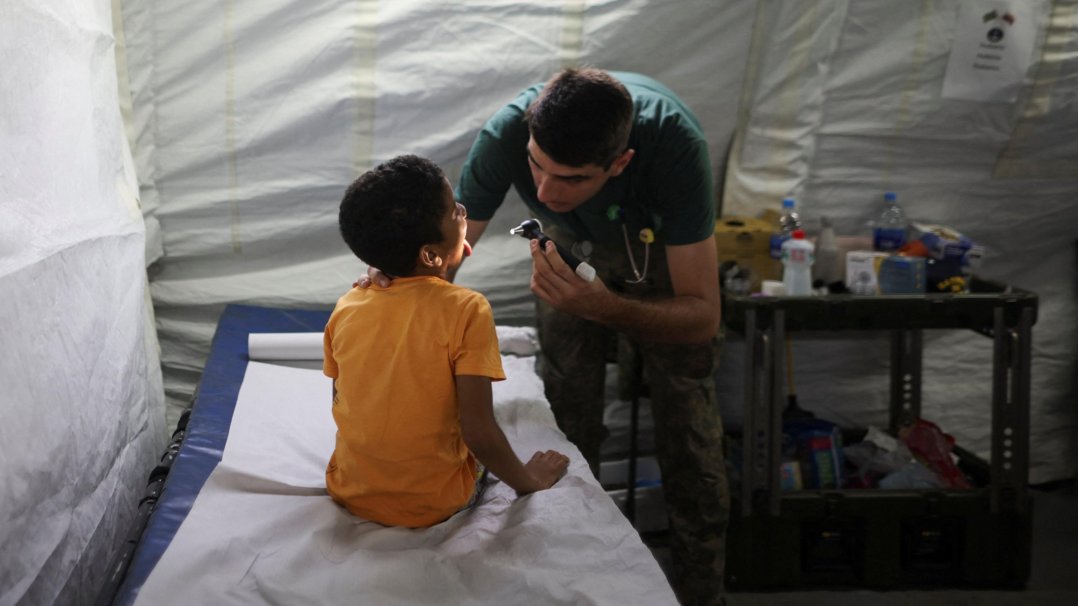 Médico revisa a un niño en un hospital de campaña en Catia La Mar