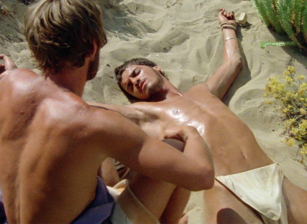 Imágen de la película Sebastiane, de Derek Jarman, en la que aparecen dos hombres con el torso descubierto.