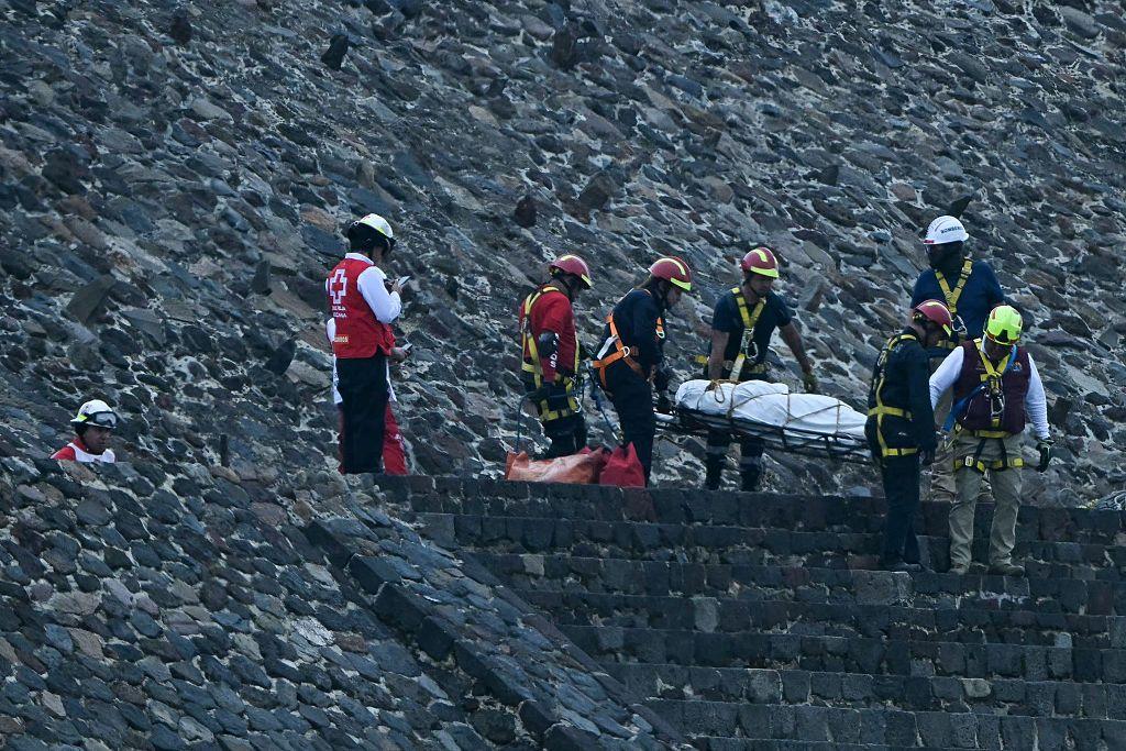 Equipos de emergencia descienden de la pirámide con el cuerpo de la turista fallecida envuelto sobre una camilla