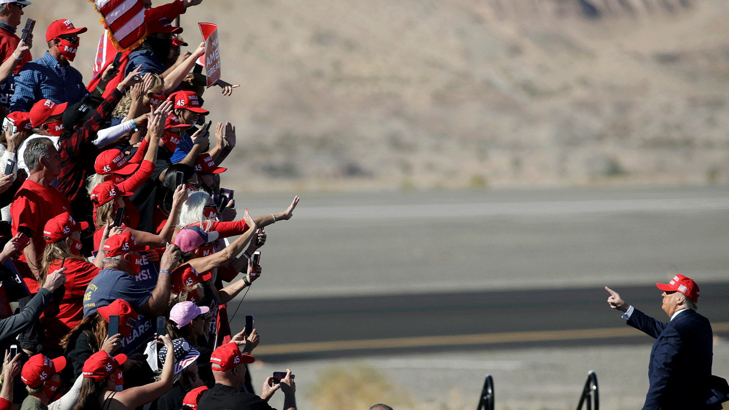 美國總統特朗普在競選集會結束後向支持者比手勢致意