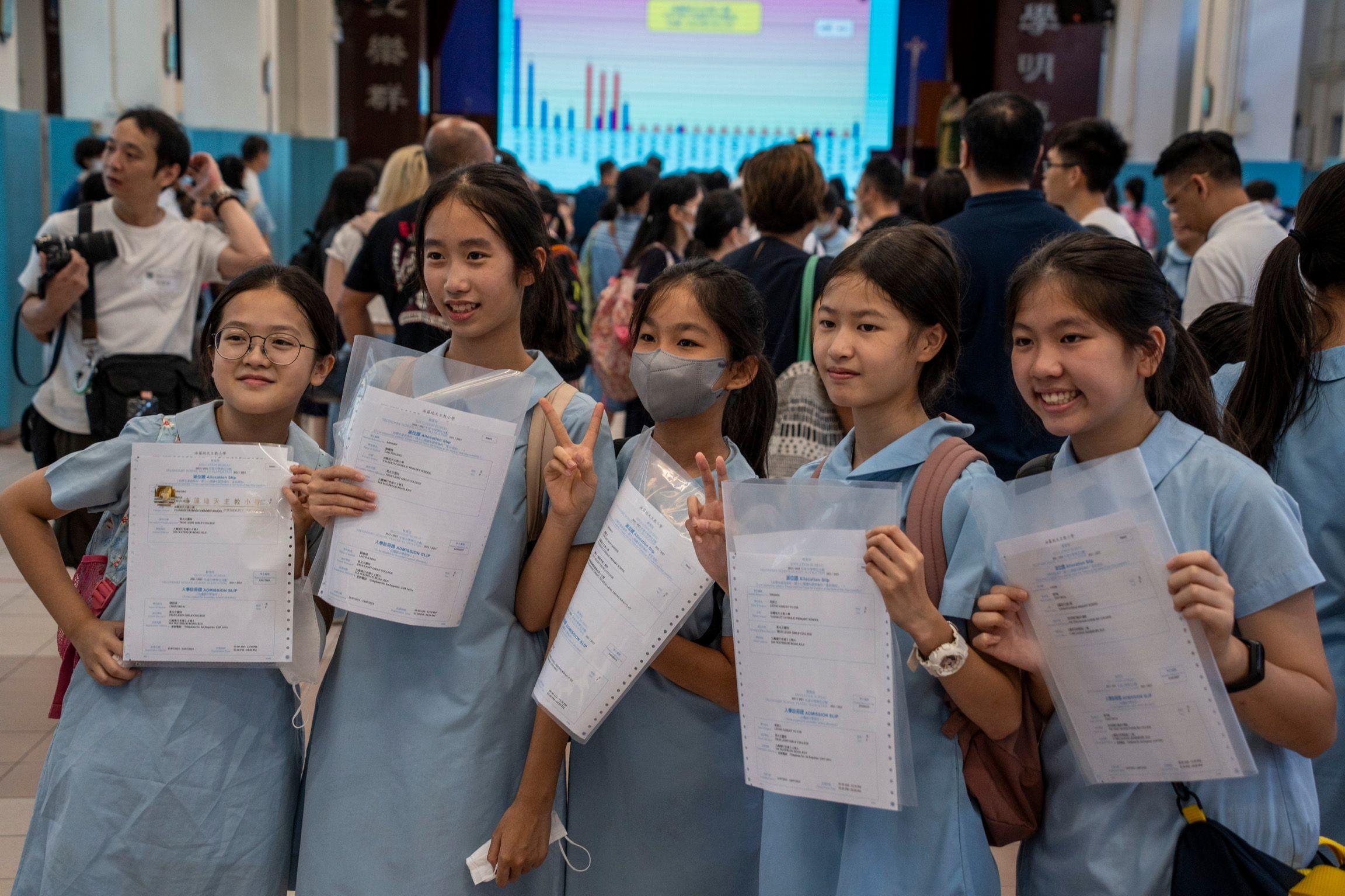 香港某小學發放中一派位結果後一群小六女生舉起派位證留影慶祝（資料圖片）