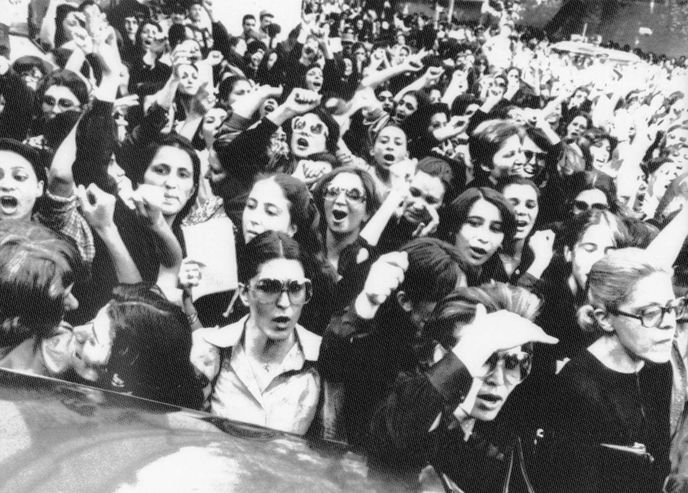 Una concentración de mujeres en la calle. Algunas están levantando los brazos