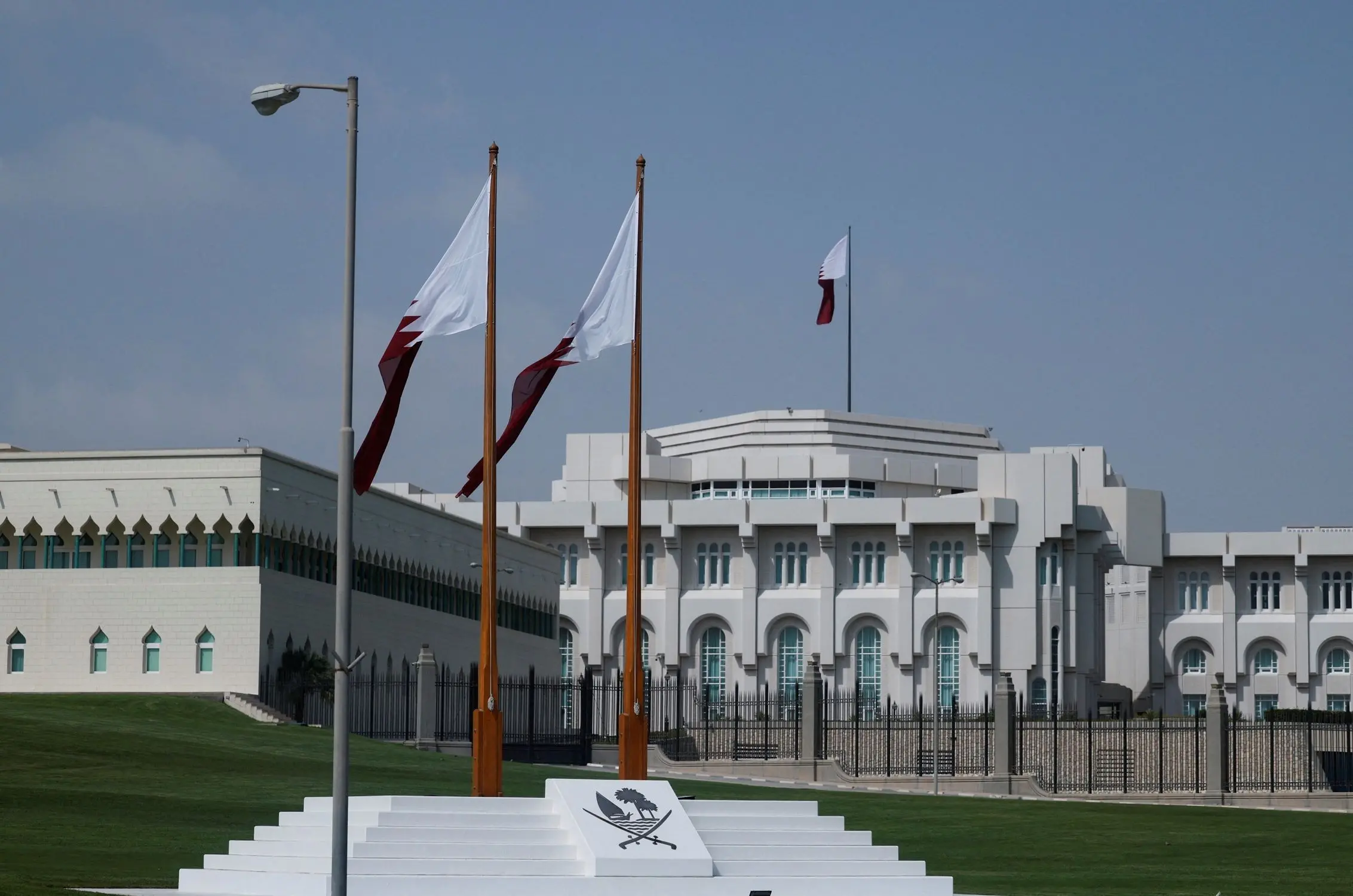 مبنى الديوان الأميري في الدوحة، لونه أبيض، أمامه ساريتين يحملان علمي قطر، وفوق المبنى سارية ثالثة، قطر، 15 سبتمبر 2025