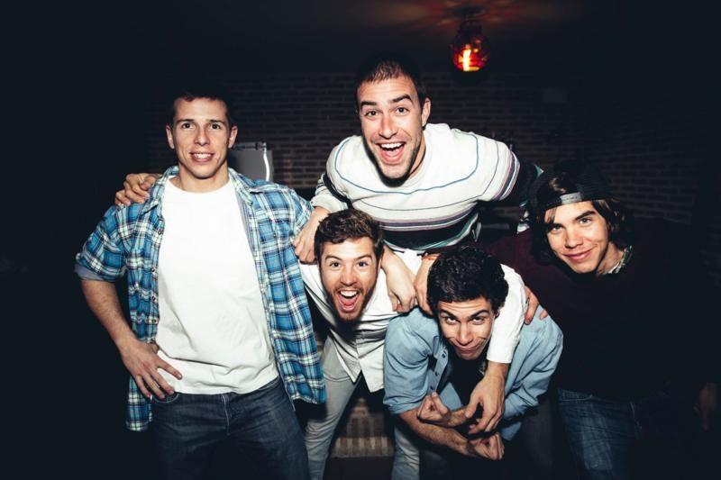 Homens jovens se amontoam alegres para posar para a foto
