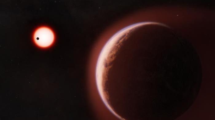 Representación artística del exoplaneta LHS 1140b, un gran planeta rocoso de color marrón rojizo que ocupa el primer plano, bordeado por un tenue resplandor atmosférico blanco azulado. En el fondo oscuro, una pequeña estrella roja brilla intensamente, con un segundo planeta más cercano mostrado como una diminuta silueta negra que cruza frente a él.