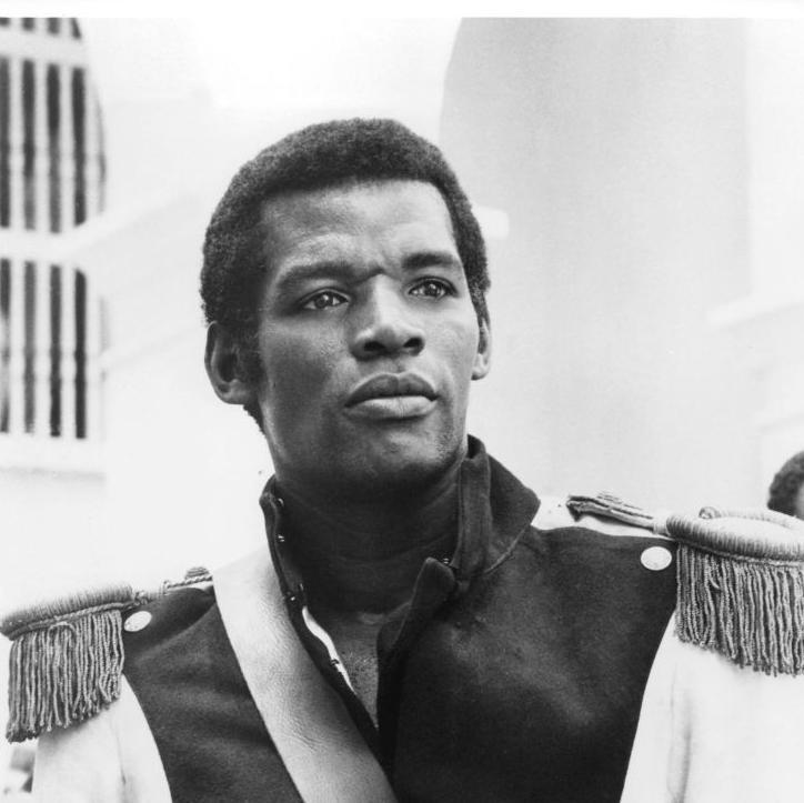 Foto en blanco y negro de Evaristo Márquez uniformado con una chaqueta militar con charreteras, en una escena de la película "Queimada"