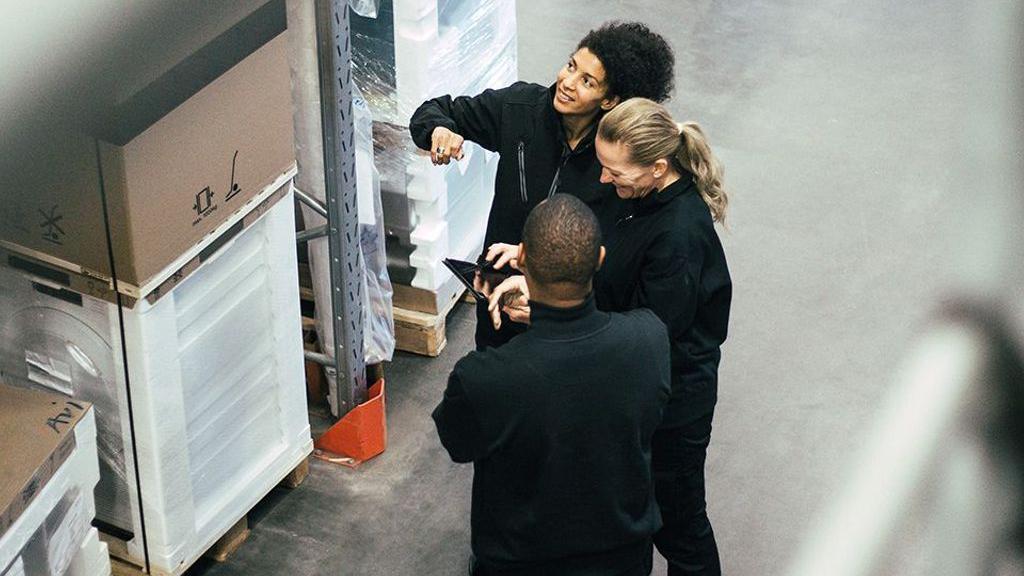 兩名女子與一名男子圍在一起在商討事情