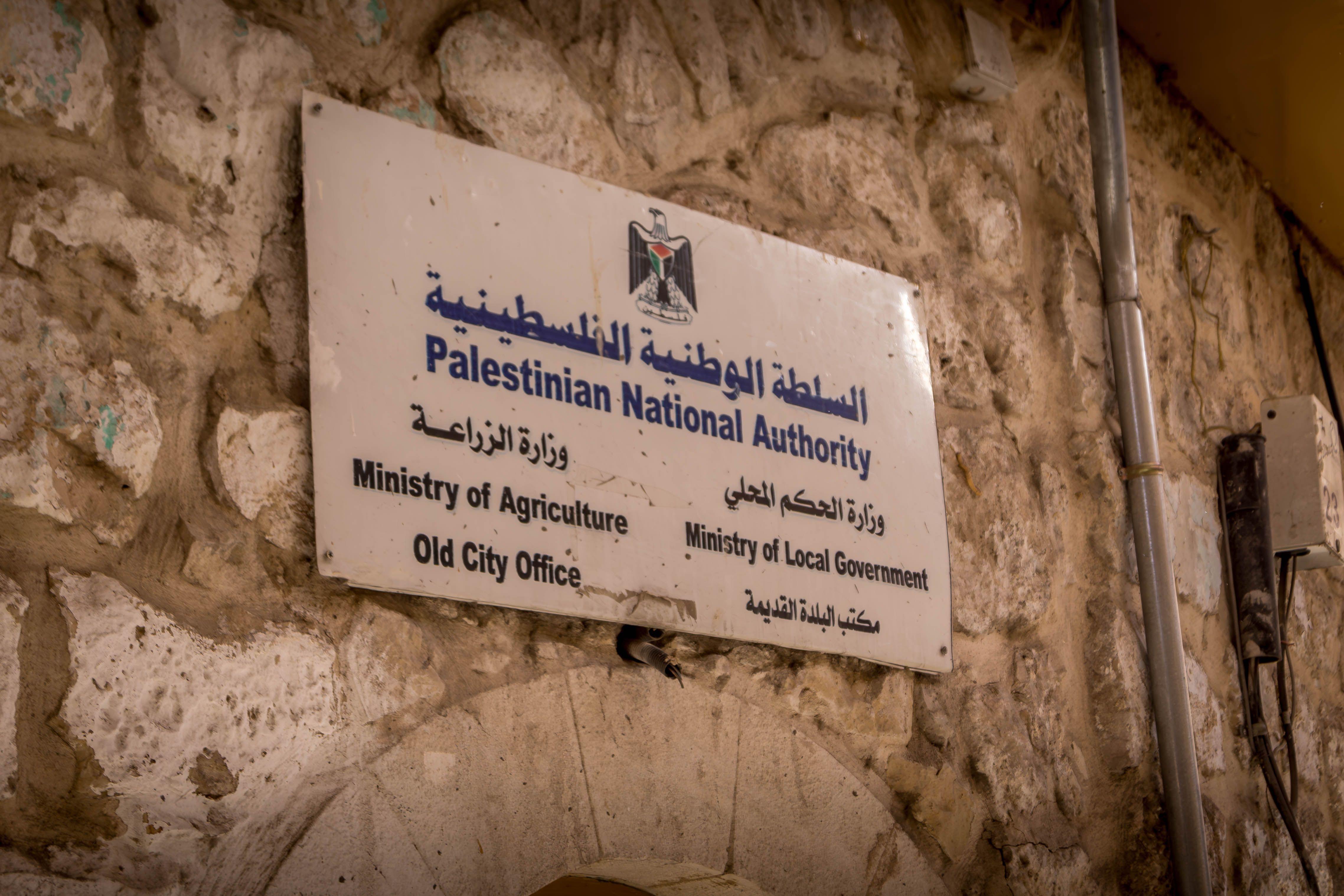 الفلسطينيون، بثلاثة مناصب رئاسية، وحكومة، وبلا دولة 4 لافتة "السلطة الوطنية الفلسطينية" مكتوبة باللغتين العربية والإنجليزية في الخليل في الضفة الغربية المحتلة