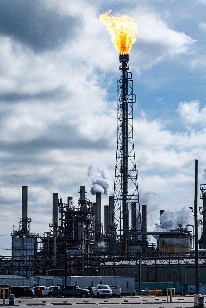 محطة لحرق الغاز والغاز الطبيعي أثناء استخراج النفط، تظهر شعلة نار من أعلى المحطة ويتصاعد الدخان أثناء عملية الاستخراج نهاراً.